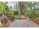 Brick patio in a wooded backyard with mature trees and garden beds surrounding the perimeter at 2739 Springfount Trl, Lawrenceville, GA 30043