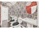 A stylish powder room features bold wallpaper, pedestal sinks, and modern lighting fixtures at 2739 Springfount Trl, Lawrenceville, GA 30043