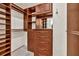 A walk in closet featuring dark wood built-in shelves, drawers, and cabinets for maximum storage at 2739 Springfount Trl, Lawrenceville, GA 30043