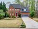 Inviting brick home boasts a lovely front yard, a gray garage, and a vibrant red front door at 2739 Springfount Trl, Lawrenceville, GA 30043