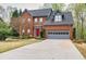 Charming two-story brick home featuring a red front door, gray garage, and well-maintained landscaping at 2739 Springfount Trl, Lawrenceville, GA 30043