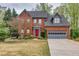 Attractive two-story brick home with a landscaped front yard, attached garage, and eye-catching red front door at 2739 Springfount Trl, Lawrenceville, GA 30043