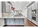 Open kitchen with gray cabinets, granite countertops, stainless steel appliances, and hardwood flooring at 2739 Springfount Trl, Lawrenceville, GA 30043