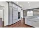 Well-lit kitchen with gray cabinets, stainless steel appliances, kitchen island, and hardwood flooring at 2739 Springfount Trl, Lawrenceville, GA 30043