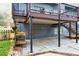 Covered patio area featuring a deck above, stone paving, and garden flowers, perfect for outdoor relaxation at 2739 Springfount Trl, Lawrenceville, GA 30043