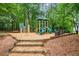 Community playground with wood chip ground cover and a variety of play structures, surrounded by trees at 2739 Springfount Trl, Lawrenceville, GA 30043