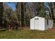 Backyard with a storage shed, surrounded by mature trees and an outdoor fire pit at 3095 Meadow Lark Ln, Atlanta, GA 30344