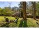 Private backyard view includes a fire pit, Adirondack chairs, and mature trees at 3095 Meadow Lark Ln, Atlanta, GA 30344