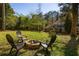 A spacious, tree-filled backyard includes a fire pit with Adirondack chairs at 3095 Meadow Lark Ln, Atlanta, GA 30344