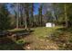 Expansive backyard with mature trees, storage shed, garden, and fire pit area at 3095 Meadow Lark Ln, Atlanta, GA 30344