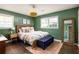 Calming bedroom featuring a wooden bedframe, hardwood floors, and ample natural light from the surrounding windows at 3095 Meadow Lark Ln, Atlanta, GA 30344