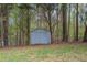 View of the outdoor shed with a grassy area and surrounded by woods at 328 Allatoona Shores Dr, Canton, GA 30114