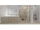 Bathroom featuring a tile enclosed tub with a glass shower and an open toilet area at 3087 Mountain Shadow Way, Marietta, GA 30064