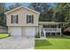 Charming two-story home with a two-car garage and a covered porch nestled among lush green trees at 3980 Carlton Cove Ct, Loganville, GA 30052