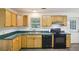 Functional kitchen has appliances, wood cabinets, laminate countertops and convenient access to the backyard at 3980 Carlton Cove Ct, Loganville, GA 30052