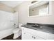 Well lit bathroom featuring a white vanity and speckled black countertop, plus shower and toilet at 4540 Bryant Rd, Buford, GA 30518