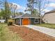 Cozy home showcasing an orange garage door, dark siding, and newly landscaped garden bed at 4540 Bryant Rd, Buford, GA 30518
