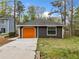 Charming single-story home featuring a striking orange garage door and a well-maintained front yard at 4540 Bryant Rd, Buford, GA 30518
