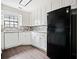Well-lit kitchen with white cabinetry, black refrigerator, and updated backsplash at 4540 Bryant Rd, Buford, GA 30518