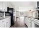Open kitchen with white cabinets, granite countertops, a black fridge, and views of dining and living areas at 4540 Bryant Rd, Buford, GA 30518