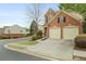Two-story brick townhome featuring a two-car garage and well-maintained landscaping on a quiet street at 1680 Fair Oak Way # 24, Mableton, GA 30126