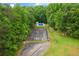 Aerial view of the property featuring a tennis court and a swimming pool, surrounded by lush greenery at 2230 Mcbrayer Ct, Cumming, GA 30028