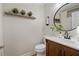 Stylish bathroom with wood vanity, round mirror, and shiplap accent wall at 2230 Mcbrayer Ct, Cumming, GA 30028