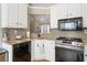 Well-lit kitchen features stainless steel appliances, granite counters, and sleek white cabinets at 2230 Mcbrayer Ct, Cumming, GA 30028