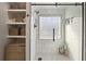 Updated shower with stylish tile, glass door, and storage shelves at 2230 Mcbrayer Ct, Cumming, GA 30028