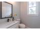 Charming half bathroom with a decorative mirror, quartz countertop, and lovely gray walls at 3068 Turning Creek Trail, Dacula, GA 30019