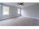 Spacious gray bedroom with carpet and two windows looking out on the lawn at 3068 Turning Creek Trail, Dacula, GA 30019