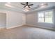 Neutral bedroom with large window, tray ceiling, and access to bathroom at 3068 Turning Creek Trail, Dacula, GA 30019