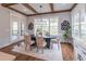Elegant dining room with hardwood floors, a modern chandelier, and large windows offering plenty of natural light at 3068 Turning Creek Trail, Dacula, GA 30019