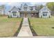 Beautifully landscaped front yard leading up to a covered front porch and inviting two-story home at 3068 Turning Creek Trail, Dacula, GA 30019