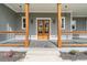 Inviting front porch with wooden columns, railing and a stylish double-door entrance at 3068 Turning Creek Trail, Dacula, GA 30019