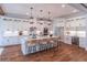 Bright, modern kitchen features white cabinets, quartz countertops, and a large island with bar seating and pendant lights at 3068 Turning Creek Trail, Dacula, GA 30019