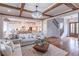 Open-concept living room with hardwood floors, coffered ceilings, a chandelier, and views into the kitchen and staircase at 3068 Turning Creek Trail, Dacula, GA 30019