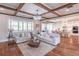 Open-concept living room with hardwood floors, coffered ceilings, and an adjacent modern kitchen at 3068 Turning Creek Trail, Dacula, GA 30019