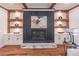 Cozy living room showcasing a modern fireplace with custom shelving and white cabinets for storage at 3068 Turning Creek Trail, Dacula, GA 30019