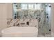 Beautiful main bathroom features a modern soaking tub, dual shower heads, and sleek marble tile at 3068 Turning Creek Trail, Dacula, GA 30019