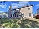 A grassy backyard featuring a two-story house with a chimney and small patio perfect for outdoor relaxation at 4463 Grove Lake St, Loganville, GA 30052