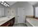 Bathroom with a sink and a bathtub with neutral paint and grey flooring at 4463 Grove Lake St, Loganville, GA 30052