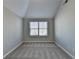 Bright bedroom with neutral-colored walls, carpeted flooring, vaulted ceiling and window with blinds allowing natural light to enter at 4463 Grove Lake St, Loganville, GA 30052