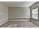 An empty bedroom with neutral carpet, large window, and built-in shelving at 4463 Grove Lake St, Loganville, GA 30052