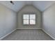 Well-lit bedroom with neutral walls, carpeted floors, vaulted ceiling and a window with blinds allowing natural light to enter at 4463 Grove Lake St, Loganville, GA 30052