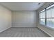 Bright, carpeted bedroom with large window and neutral-colored walls at 4463 Grove Lake St, Loganville, GA 30052