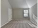 Bedroom featuring neutral walls, carpeted flooring, vaulted ceiling, and a window with blinds allowing natural light to enter at 4463 Grove Lake St, Loganville, GA 30052