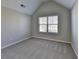 Bright bedroom with neutral walls, carpeted floors, vaulted ceiling and a window with blinds allowing natural light to stream in at 4463 Grove Lake St, Loganville, GA 30052