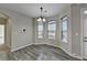 Bright dining area features three sunny windows, wood floors, and a modern chandelier at 4463 Grove Lake St, Loganville, GA 30052