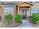 Inviting front entrance with brick accents, manicured bushes, and a covered porch at 4463 Grove Lake St, Loganville, GA 30052